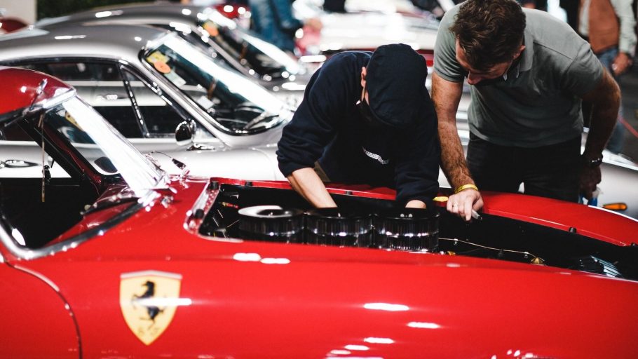 Un duo concentrato di meccanici che lavora diligentemente su un motore Ferrari